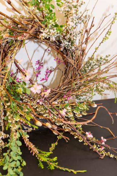 A finished wreath incorporates many of the more delicate flowering shrubs with a central focal point of redbud and plum branches. 