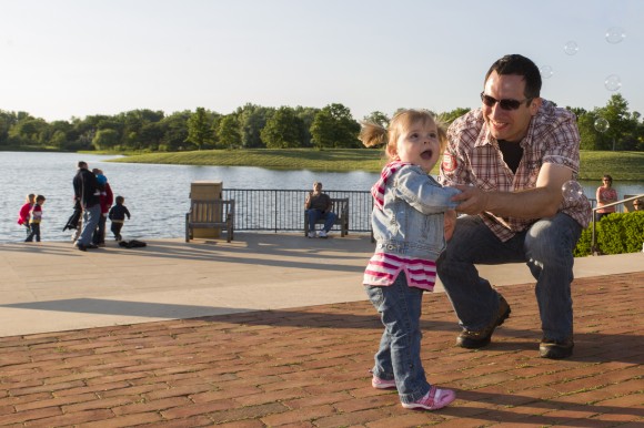 PHOTO: A dad dances with his daughter, who is amazed by some bubbles in the air.