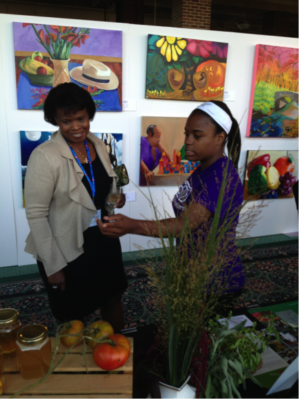 PHOTO: GYF student Tatiana talking with a guest about the farm's honey.