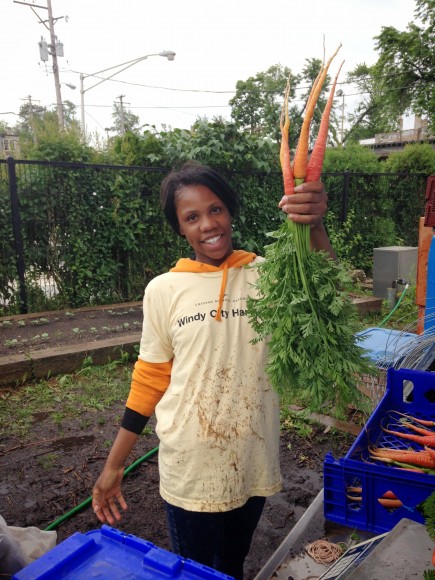 PHOTO: Juaquita holds up a freshly washed carrot harvest.