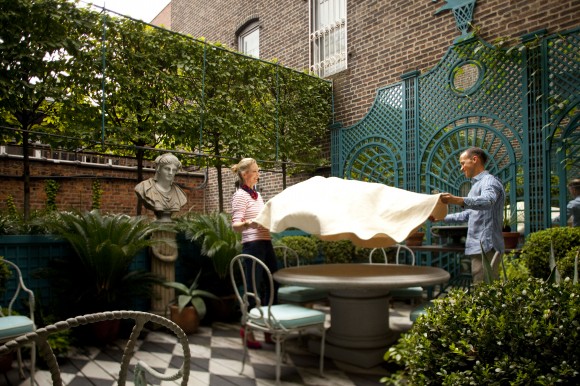 PHOTO: Danielle Rollins and Miles Redd hold a tablecloth over his stone circular garden table.