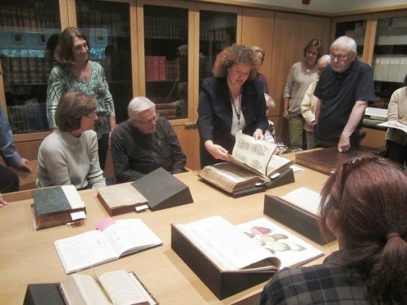 PHOTO: A meeting with a dozen people gatherered around rare books.