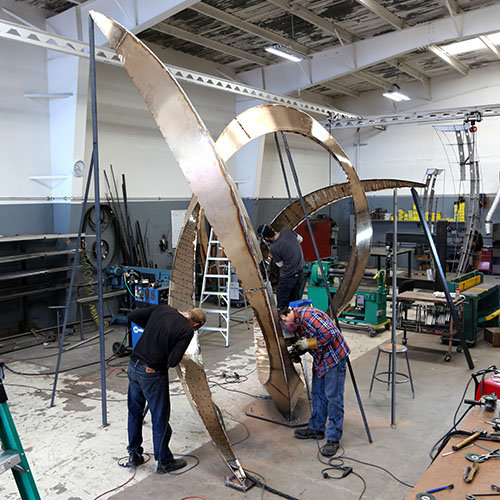 Photo: Studio staff assist in welding a larger piece.