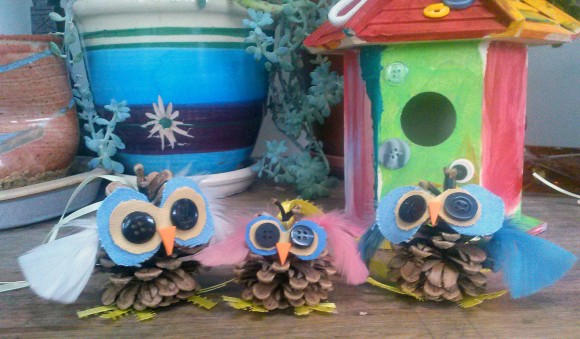 PHOTO: A family of hand-made pinecone owls using buttons for eyes and ribbon feet.
