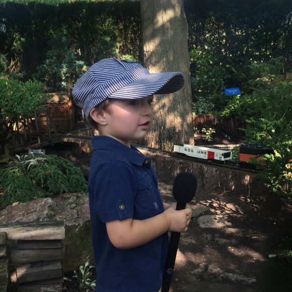 Small boy with a microphone talks about the Model Railroad Garden.