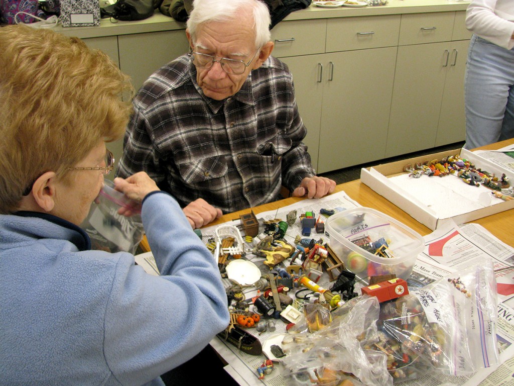PHOTO: George and Judy Knuth sorting a pile of miniatures.