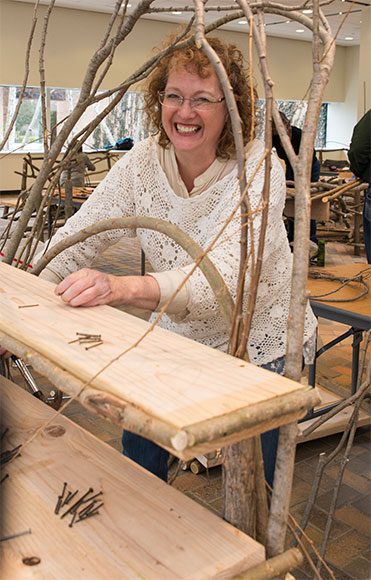 A happy Bim WIllow student works on her rustic shelf from an earlier workshop.